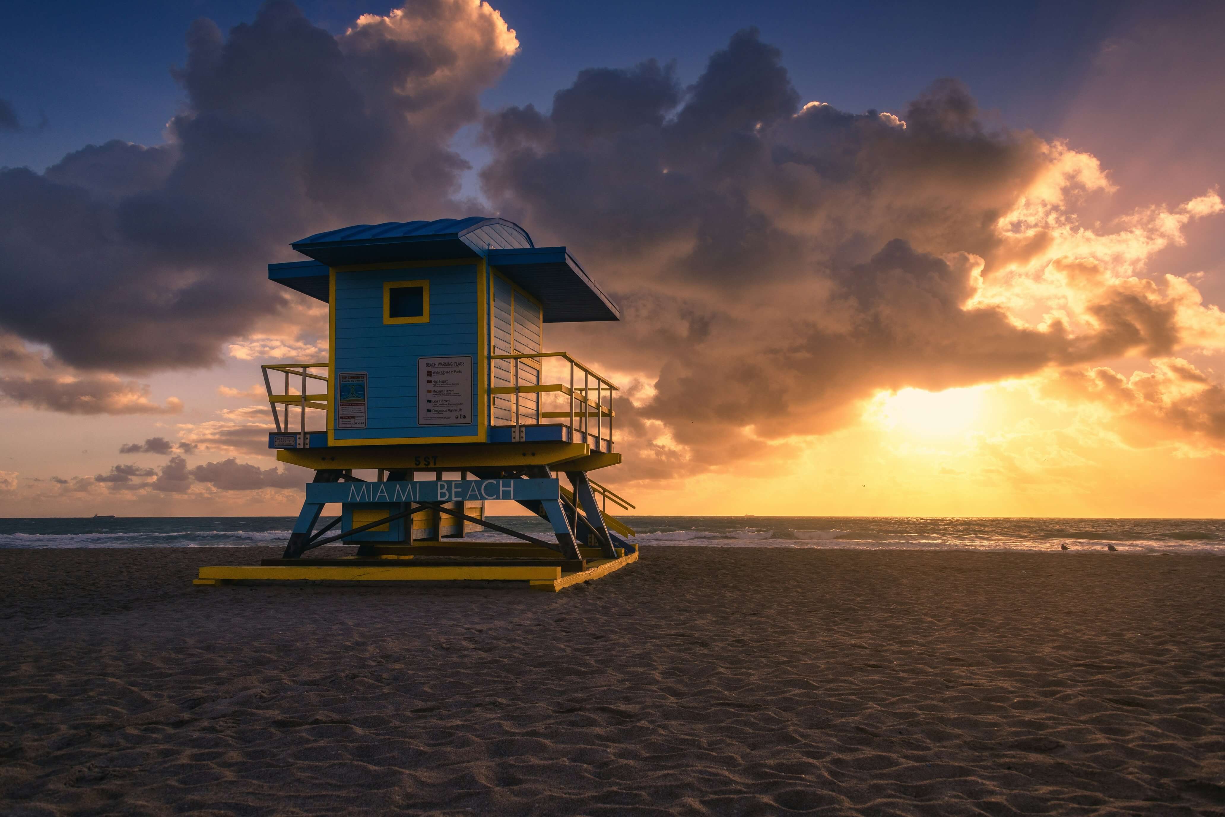 A lifeguard tower on a beach at sunset