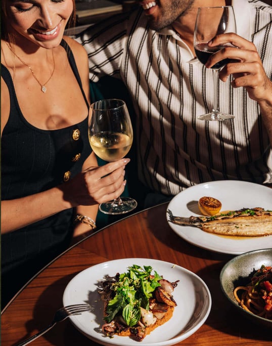 Guests enjoying their meals at Orilla Bar & Grill, sitting at tables with delicious food
